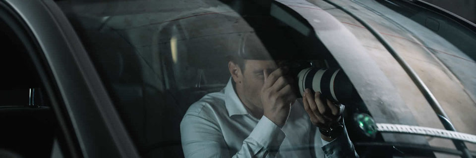 image d'un détective privé dans son véhicule qui prend une photo